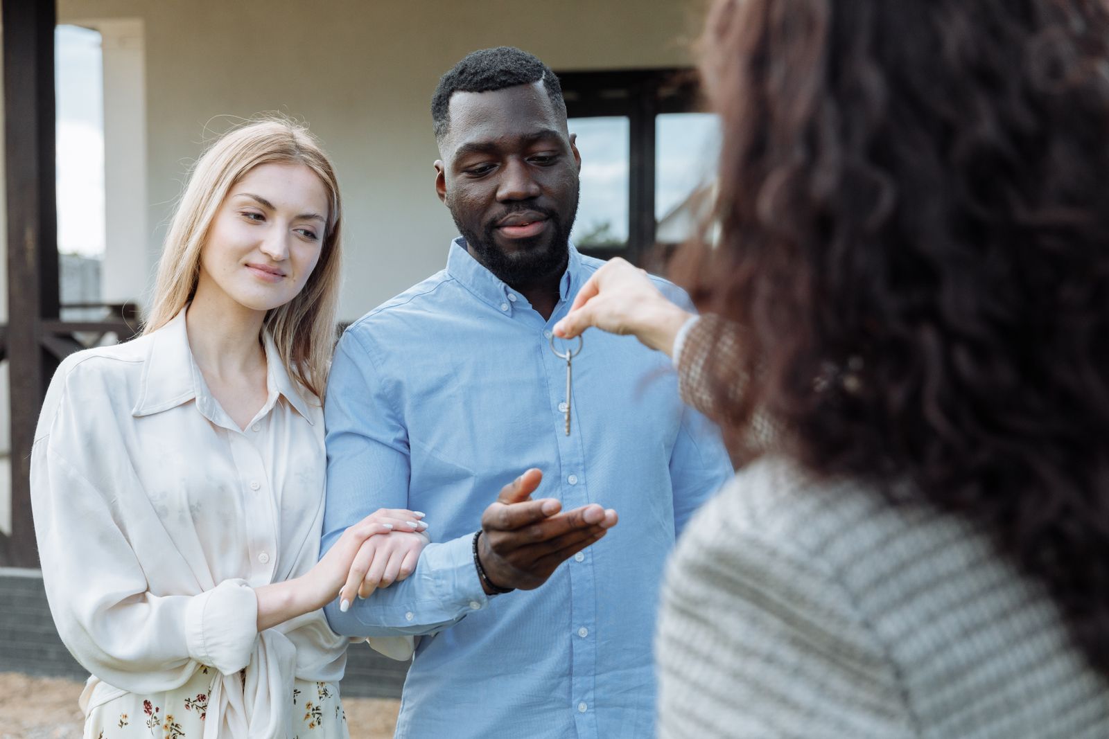 Buyers receiving keys outside their new home